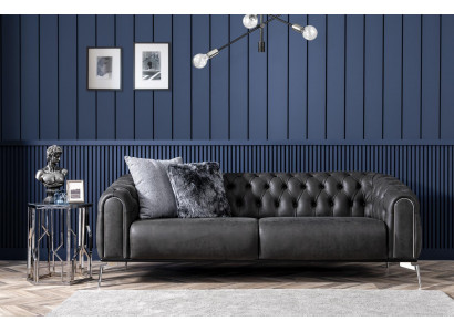 Czarna prosta czteroosobowa sofa w stylu Chesterfield w salonie