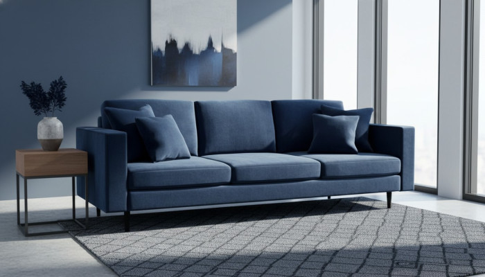 Niebieska czteromiejscowa kanapa z tkaniny w nowoczesnym stylu do salonu. Sofa z pikowanymi poduchami. Sofy wykonane z weluru.