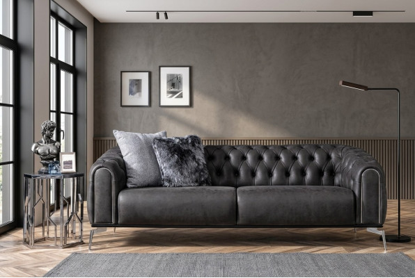 Czarna prosta czteroosobowa sofa w stylu Chesterfield w salonie