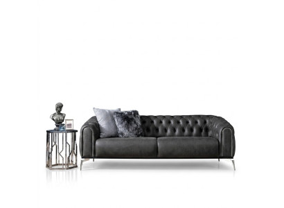 Czarna prosta czteroosobowa sofa w stylu Chesterfield w salonie
