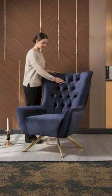 Luksusowy niebieski fotel Chesterfield z aksamitną tapicerką w salonie