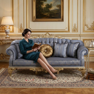 Wyrafinowana klasyczna sofa w stylu Chesterfield w salonie ze złotymi poduszkami
