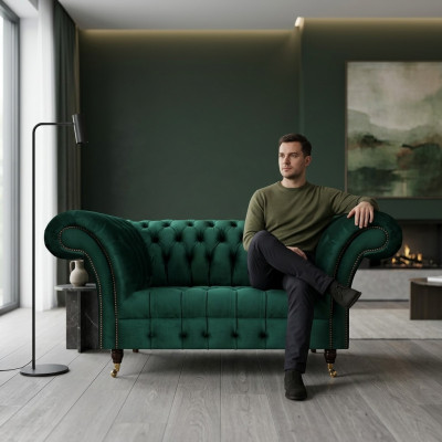 Zielony dwuosobowy designerski kanap Chesterfield obity tkaniną nobilną.