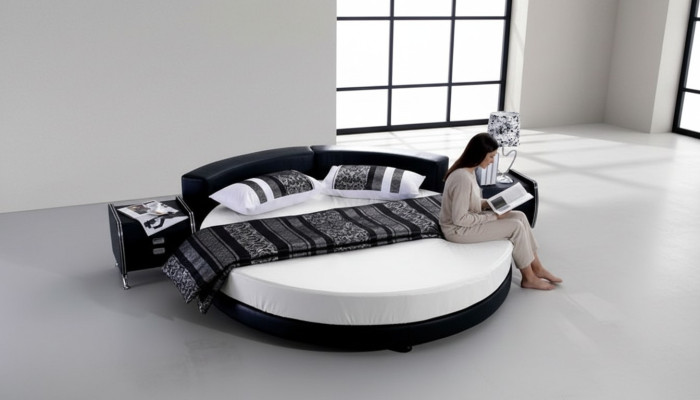 Czarna okrągła łóżko z nowoczesnym designem, eleganckimi detalami i sofą